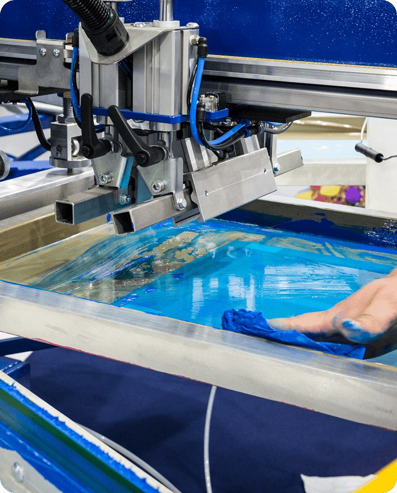 Screen printing machine applying blue ink.
