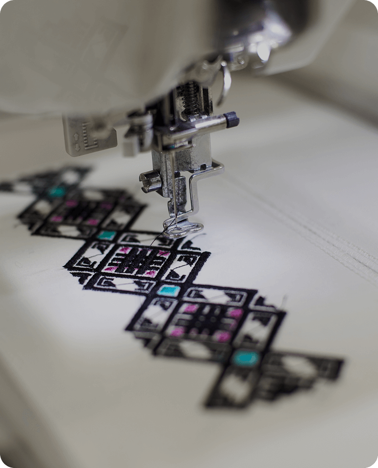Embroidery machine stitching colorful geometric pattern.
