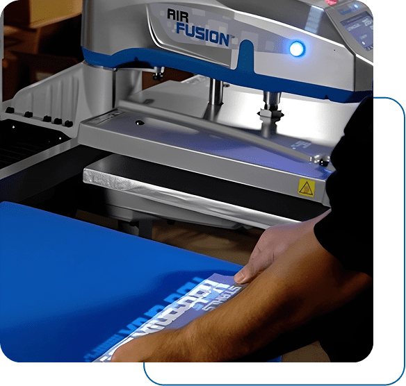 A person using a heat press machine on blue fabric.