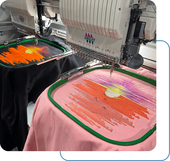 A machine embroidering a colorful design on a pink fabric.